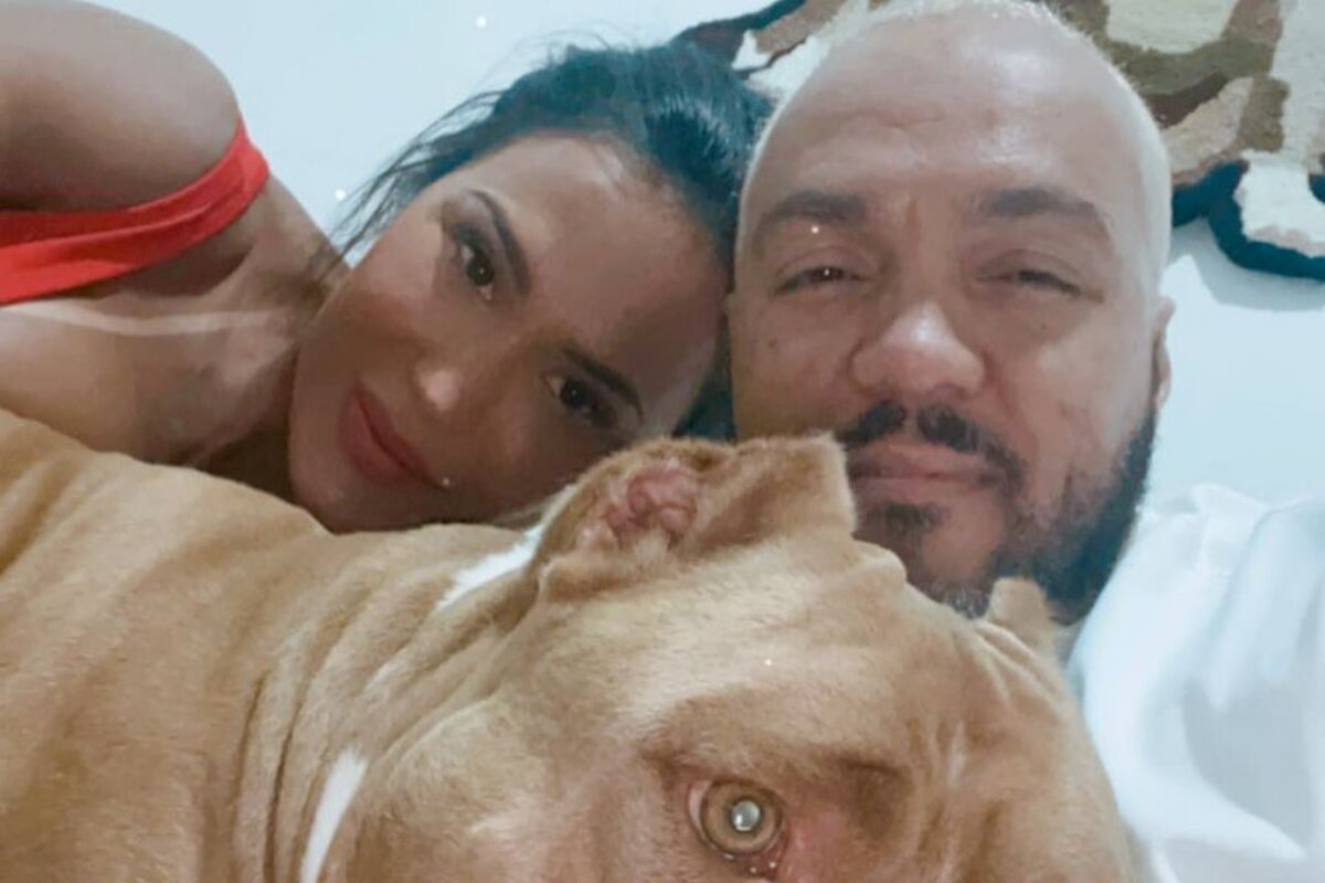 Gracyanne e Belo deitados com o cachorro