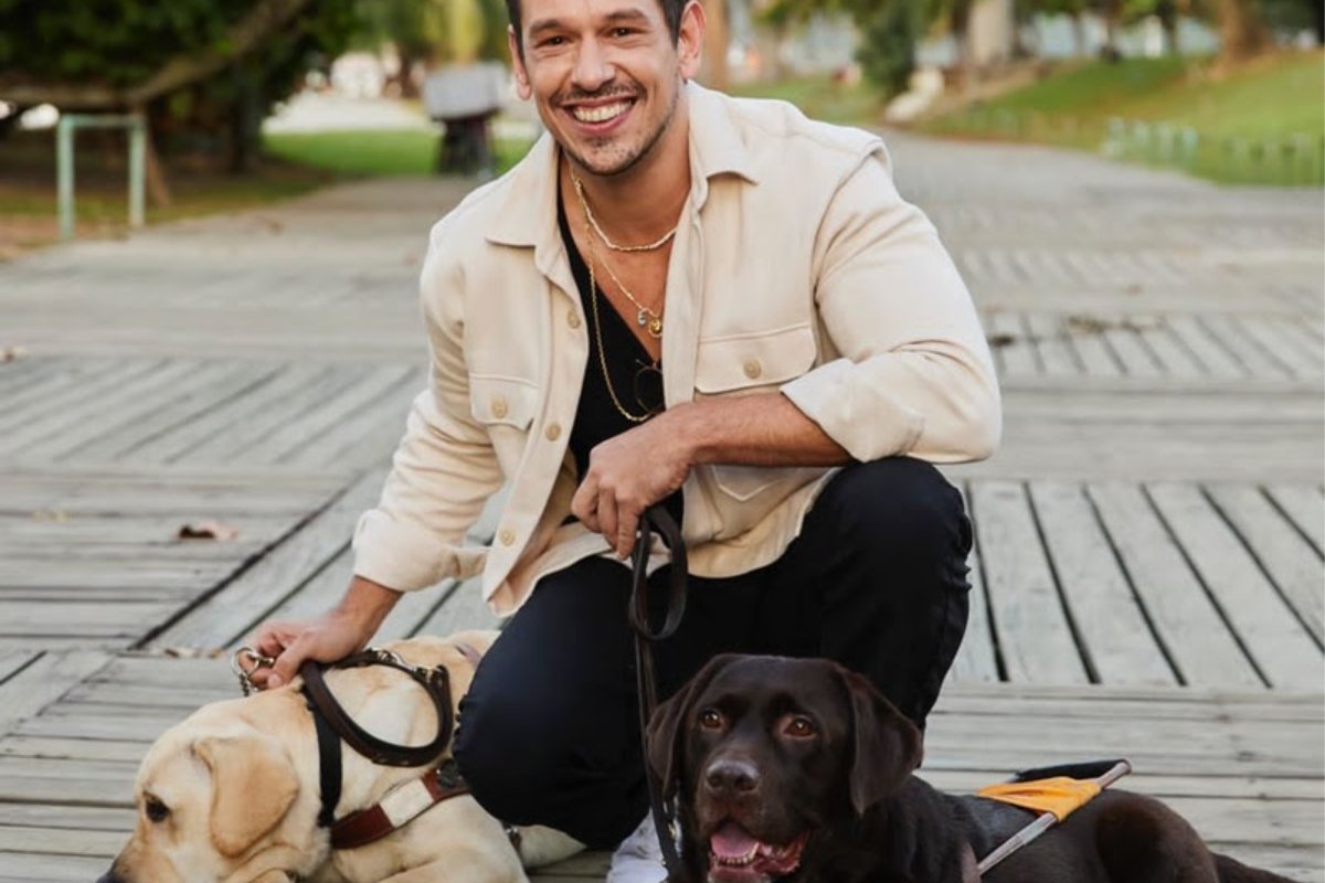 joão vicente de castro posando agachado com dois cachorros