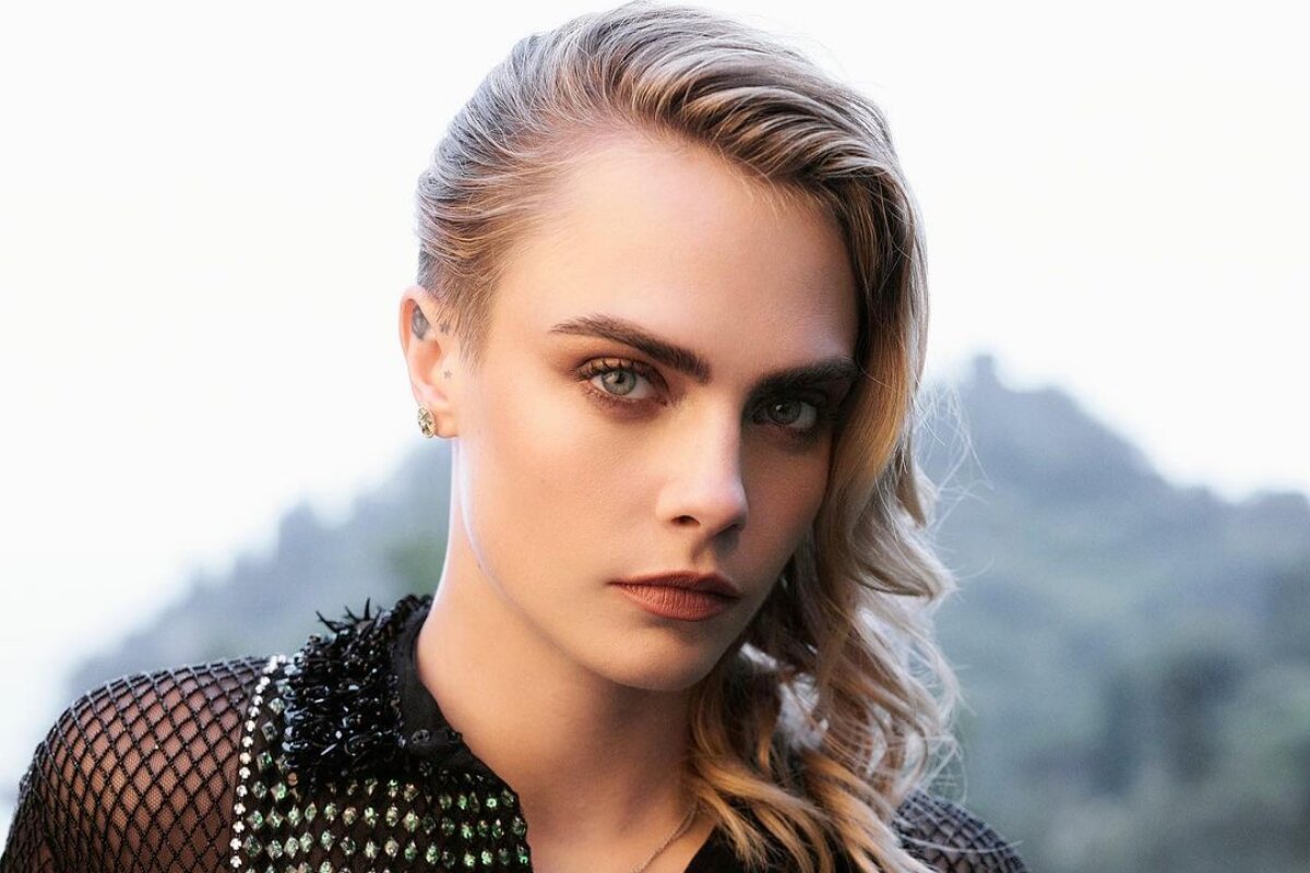 Cara Delenvigne de preto, com os cabelos pro lado