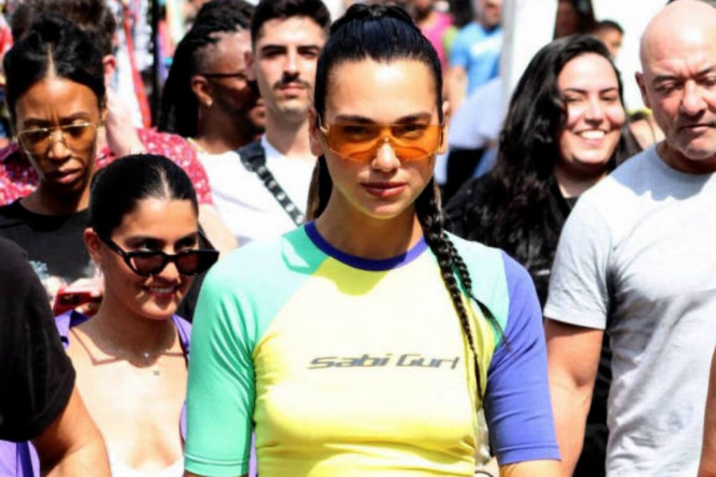 Dua Lipa com camisa verde e amarela, no meio da multidão, na escadaria Selaron, na Lapa, RJ