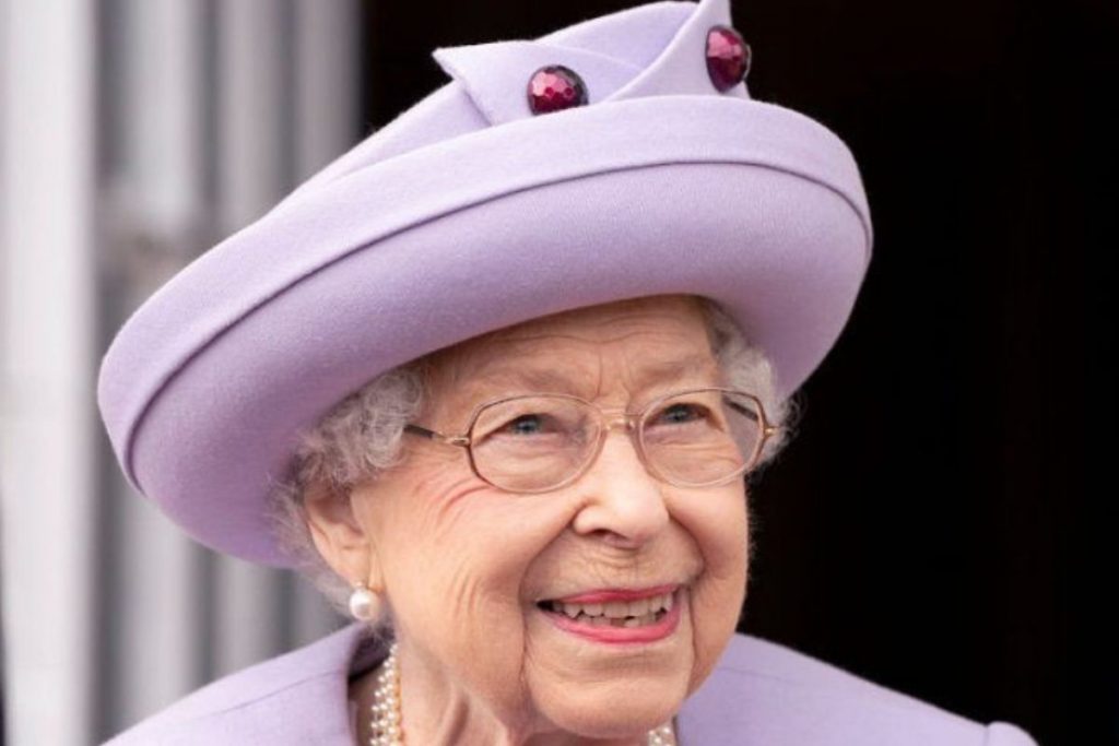rainha-elizabeth-ii-chapeu-lilas-1024x683-1 Rainha Elizabeth, sorridente, de chapéu lilás