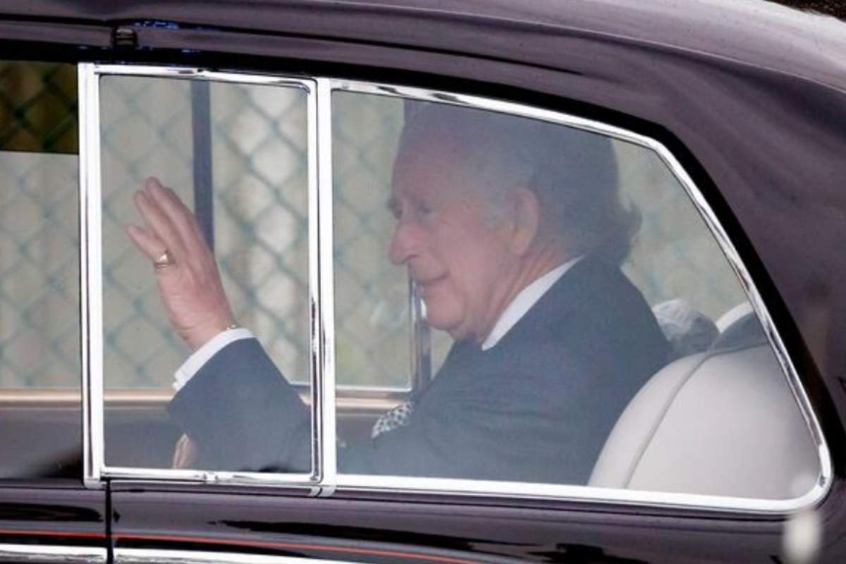 Rei Charles III acenando, dentro do carro