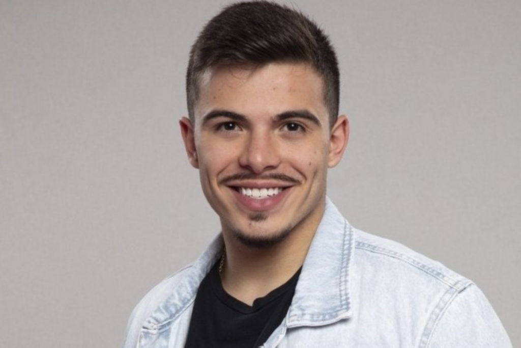 thomaz costa posando sorridente para a fazenda com blusa jeans