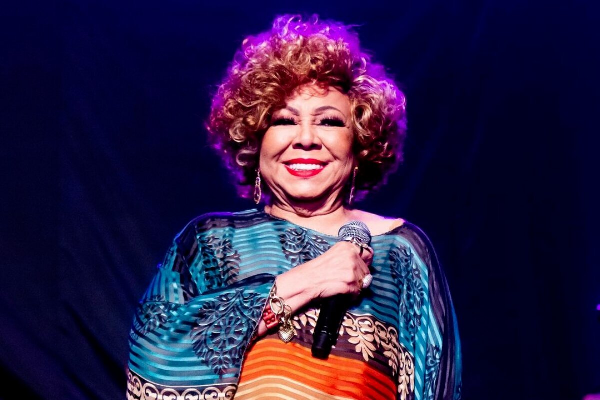 Alcione no palco, de vestido estampado azul