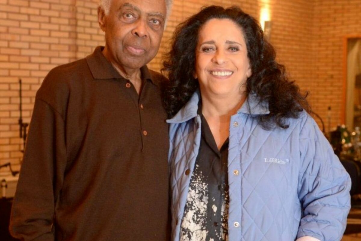 Gilberto Gil de marrom abraçado à Gal Costa, de camisa jeans