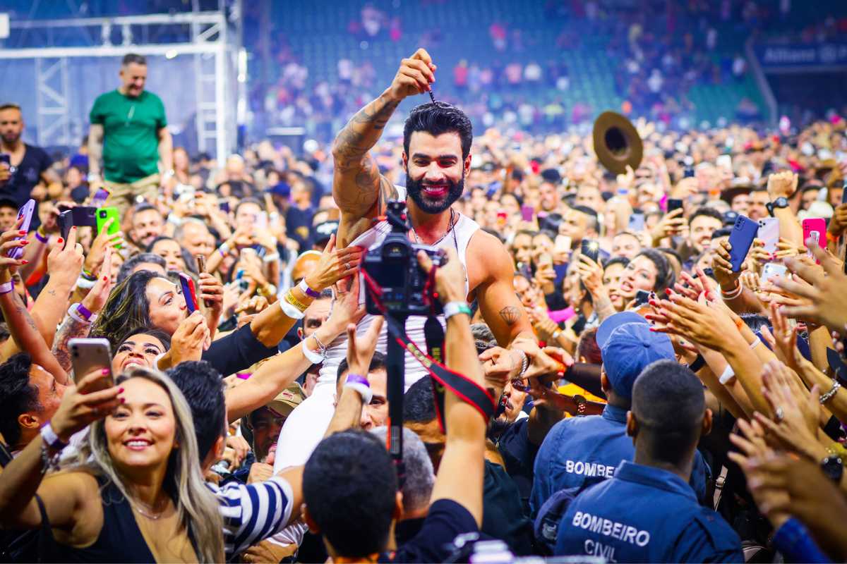 Gusttavo Lima se jogando nos fãs em show no festival Buteco