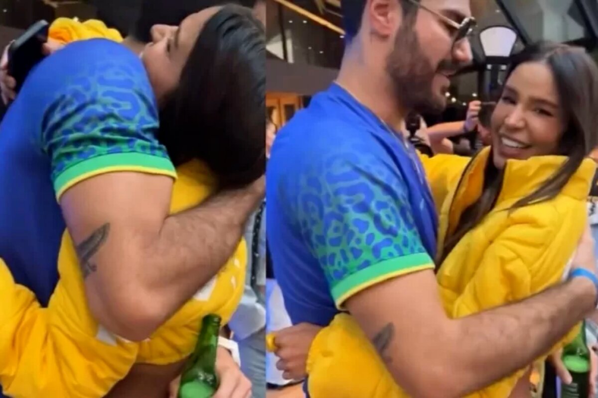 Shay de camisa azul e Kerline de amarelo, abraçados