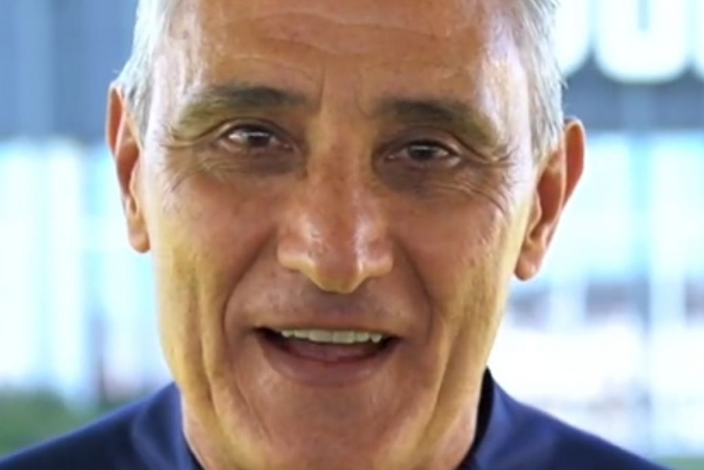 Tite, técnico da Seleção Brasileira, sorridente, olhando para a câmera