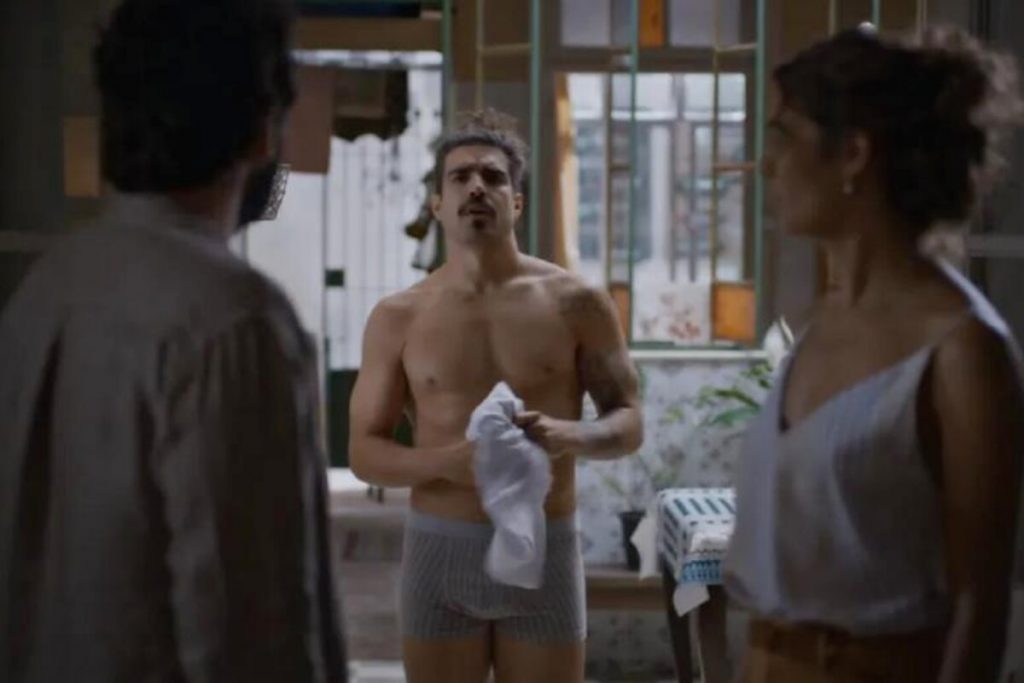 Pablo (Caio Castro) de cueca em casa, em Todas as Flores, diante de Maíra (Sophie Charlotte) e Rafael (Humberto Carrão)