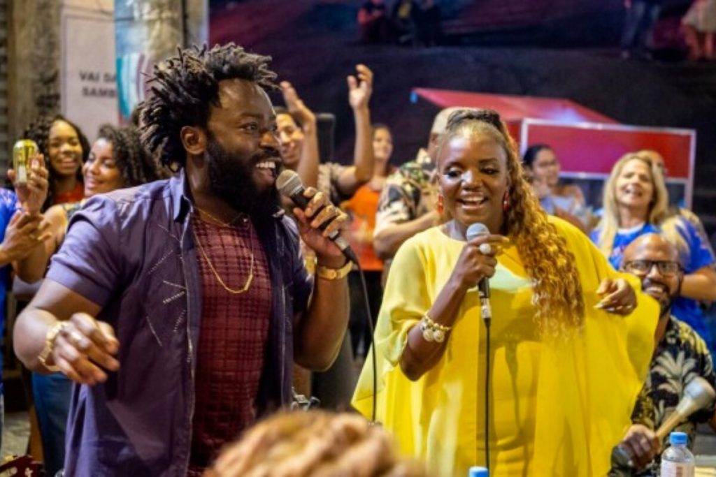 Oberdan (Douglas Silva) e Jussara (Mary Sheila), de vestido amarelo,em "Todas as Flores", cantando pagode