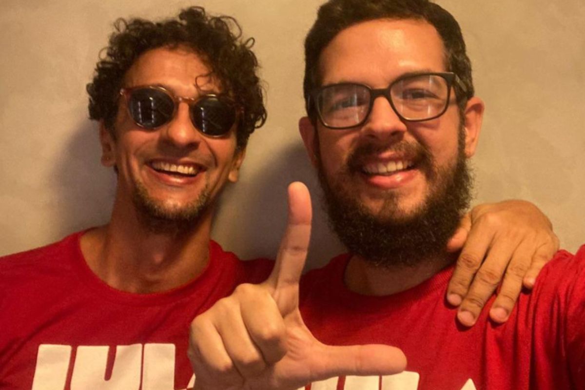 Irandhir Santos e o marido sorrindo para a câmera