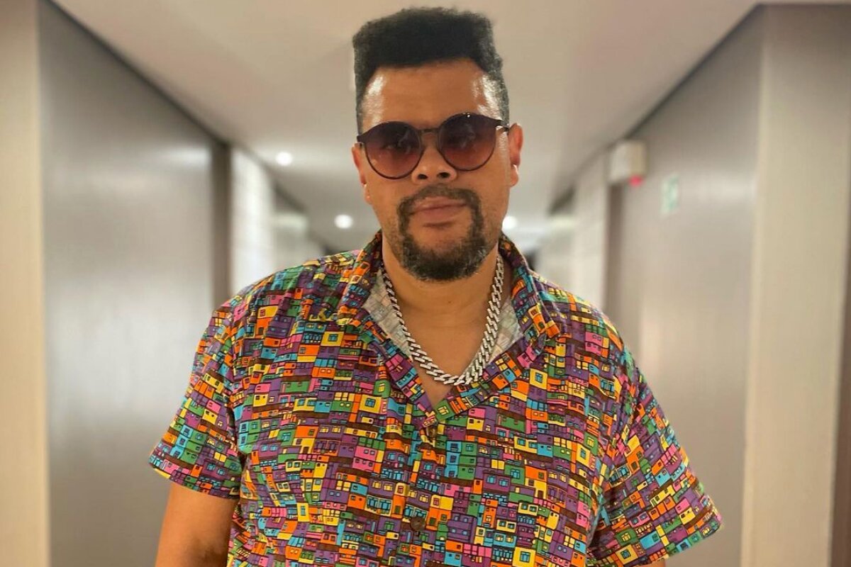 Babu Santana de camisa estampada e óculos escuros