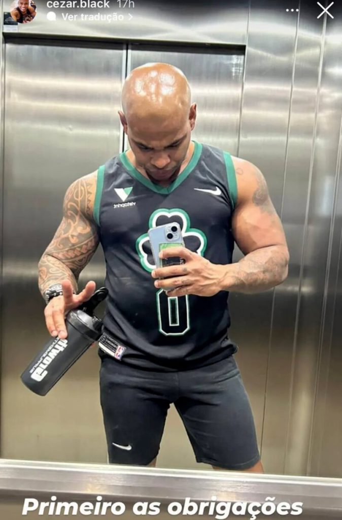 Cezar Black, da Pipoca, no elevador, com roupa de treino