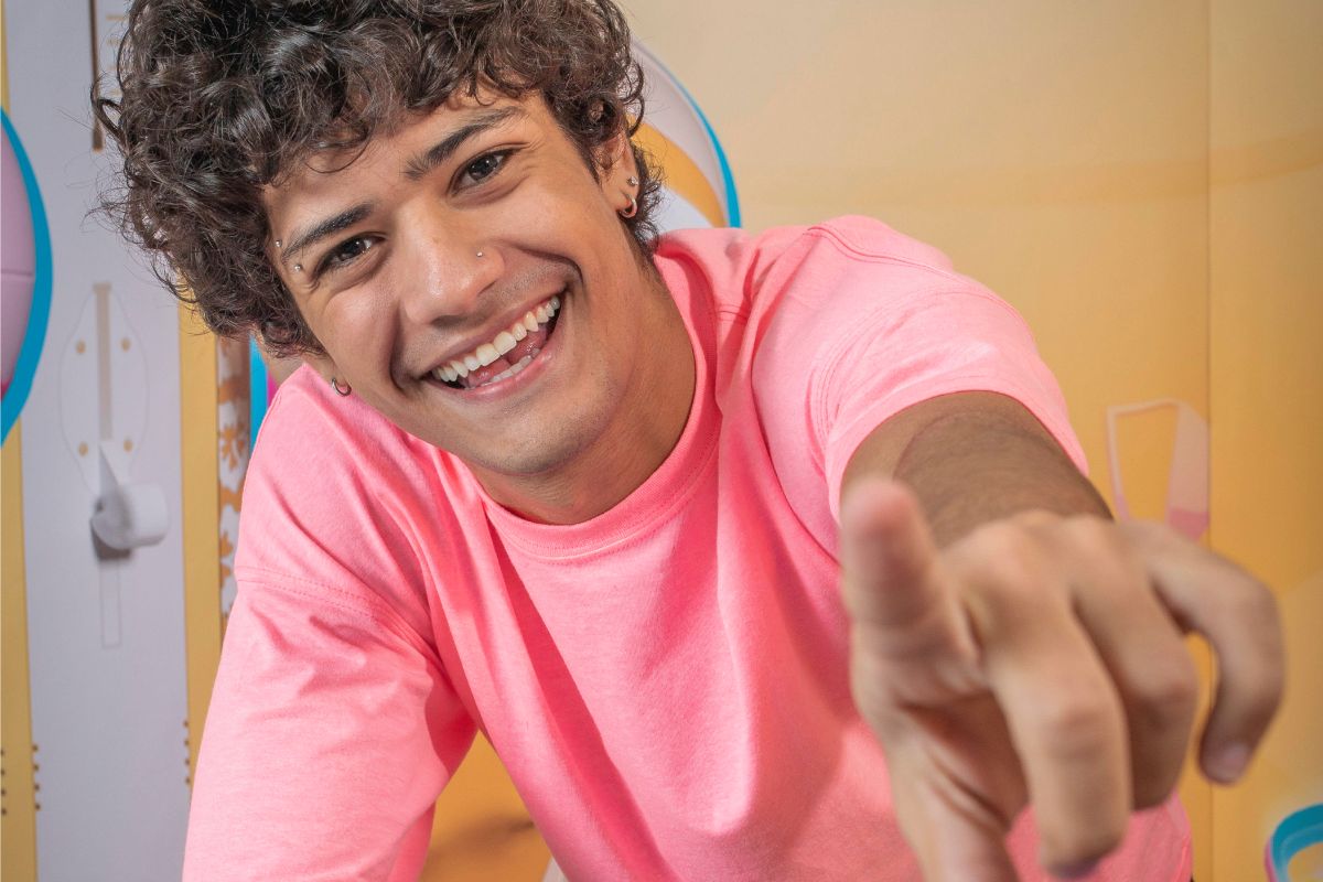 Gabriel Santana sorridente apontando para frente no bbb23