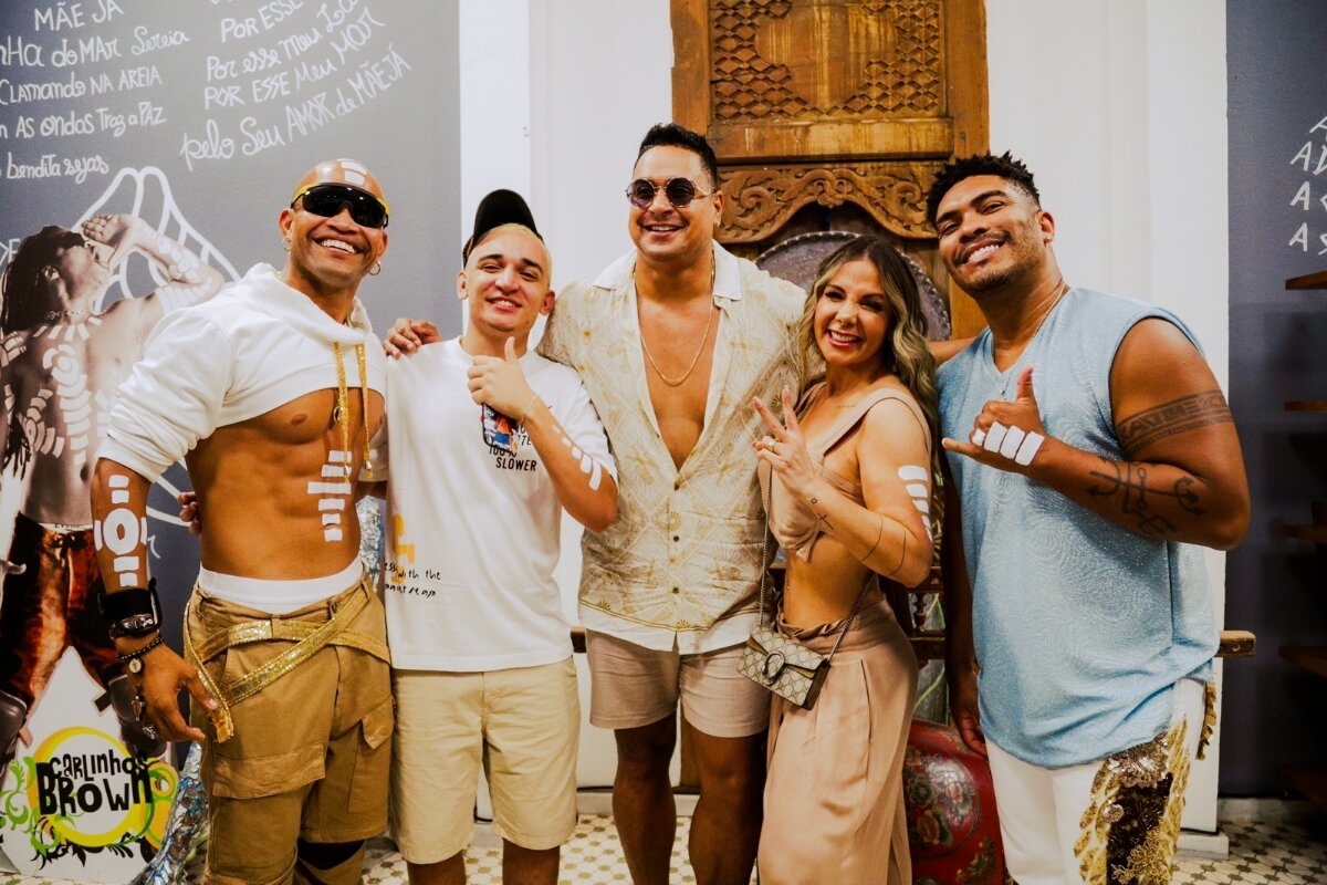 Timbalada, Xanddy e Carla Perez, abraçados e sorrindo