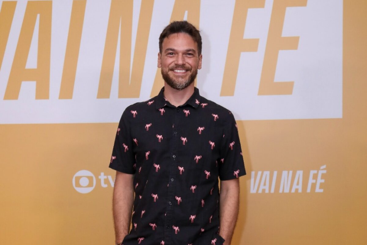 Emilio Dantas de camisa preta estampada, sorrindo