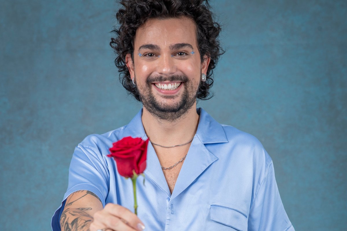 vitor dicastro posando sorridente segurando uma flor