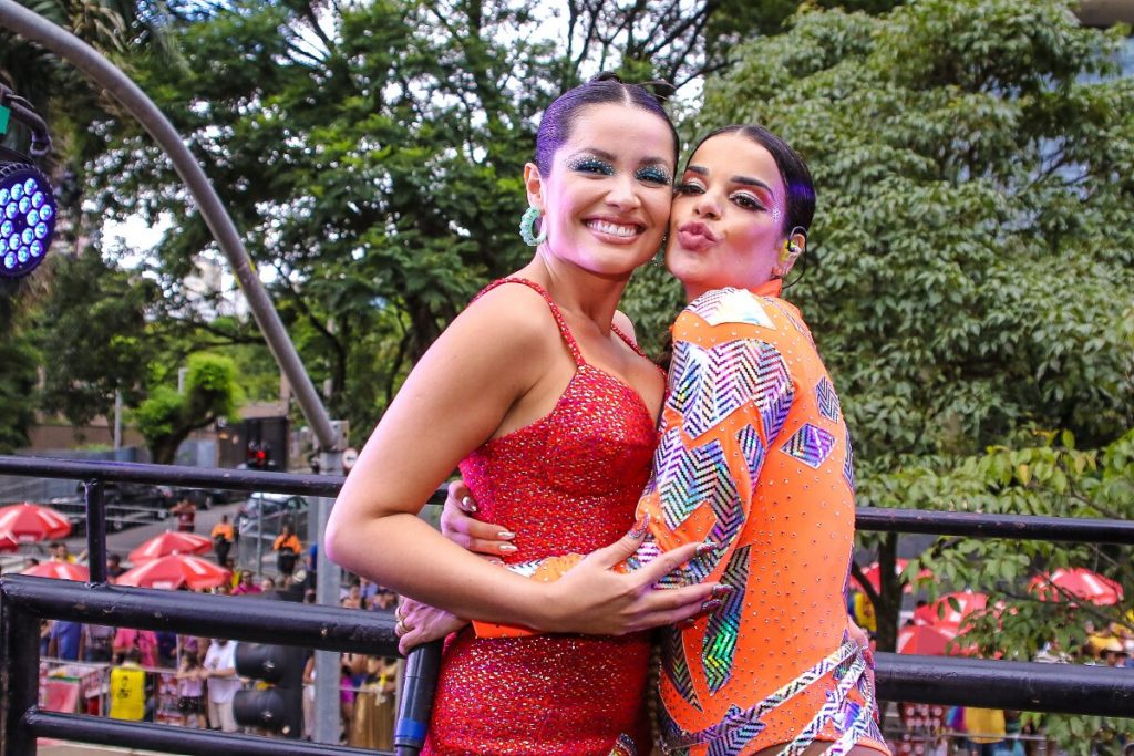 Juliette de vestido vermelho e Mari Antunes de body laranja