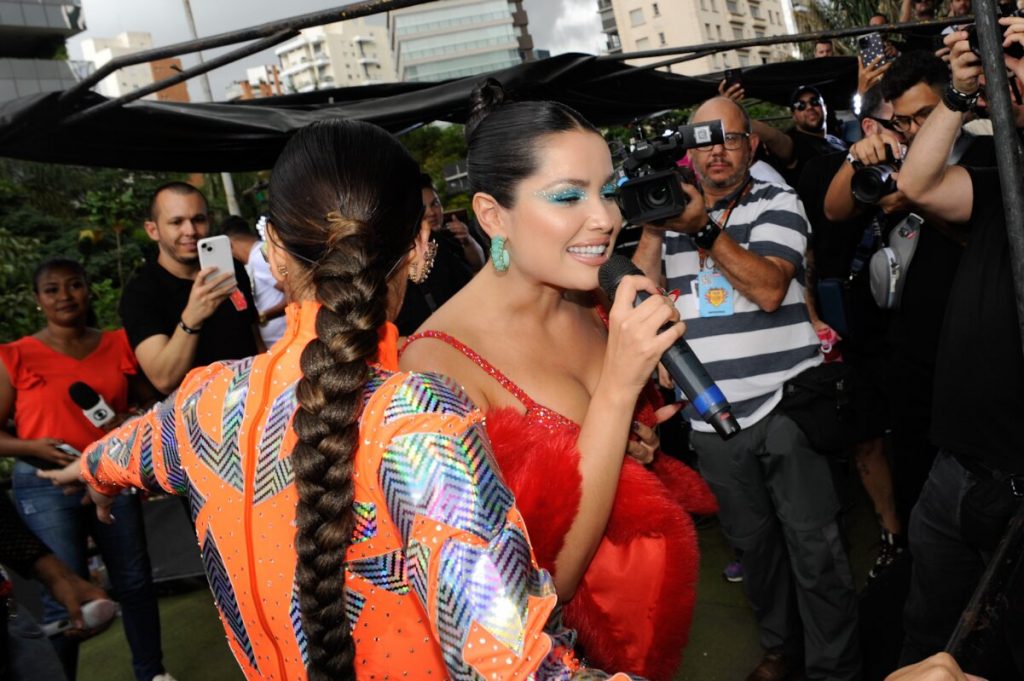 Juliette de vestido vermelho e Mari Antunes de body laranja