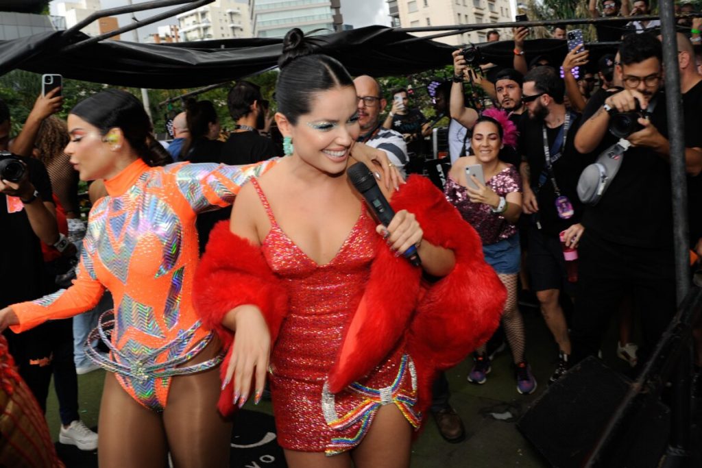 Juliette de vestido vermelho e Mari Antunes de body laranja