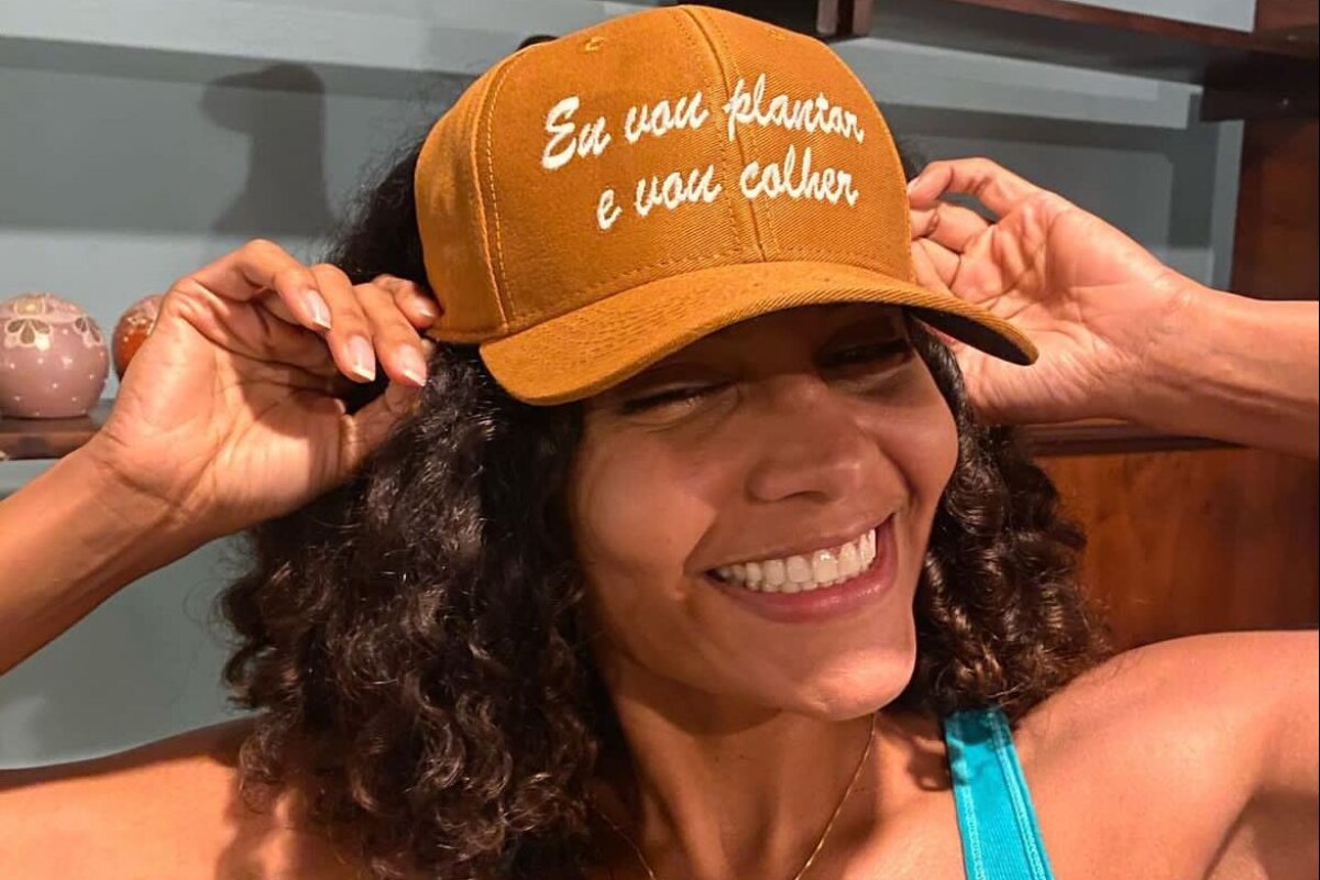 Barbara Reis de boné, sorrindo