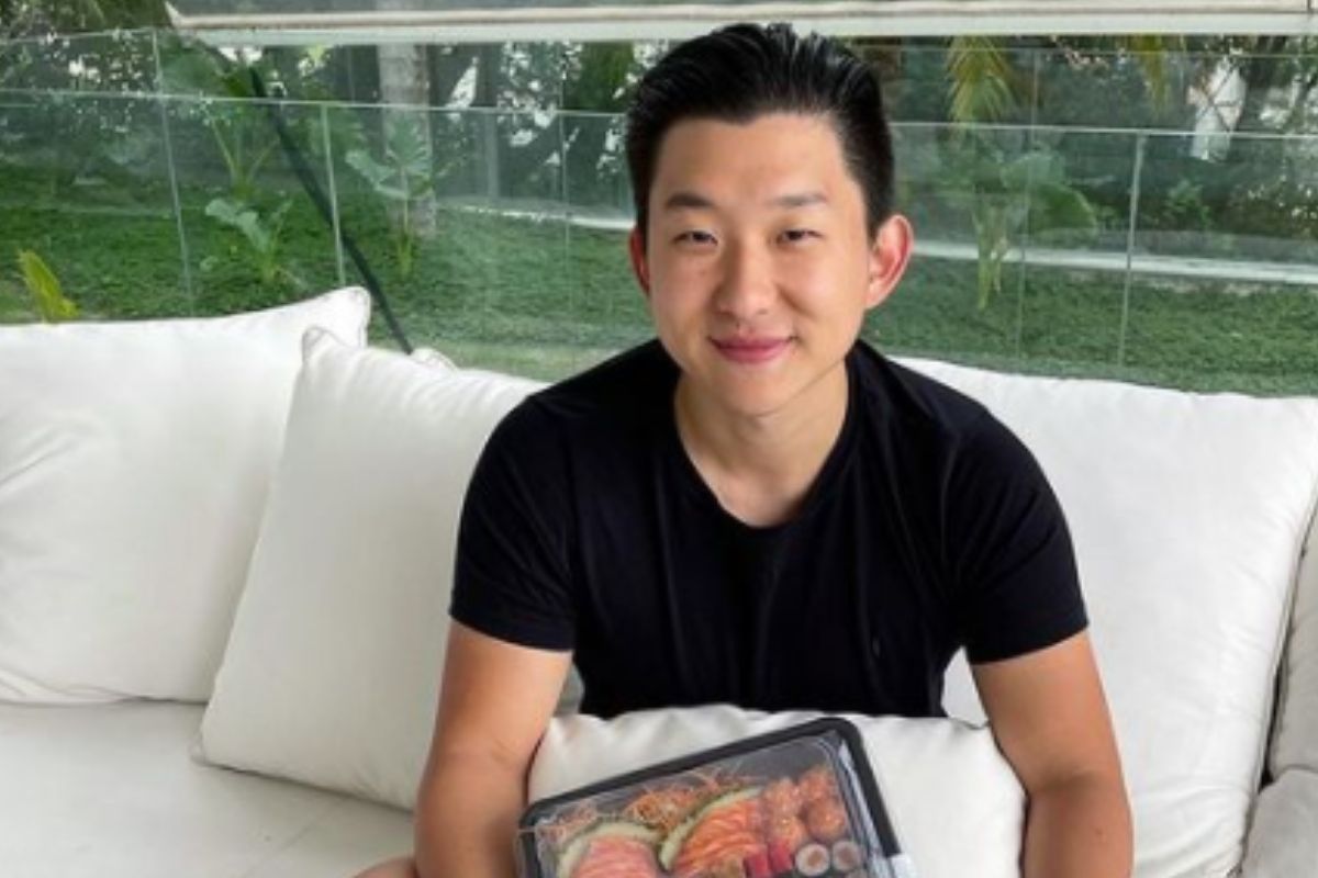 Pyong Lee sentado na cama