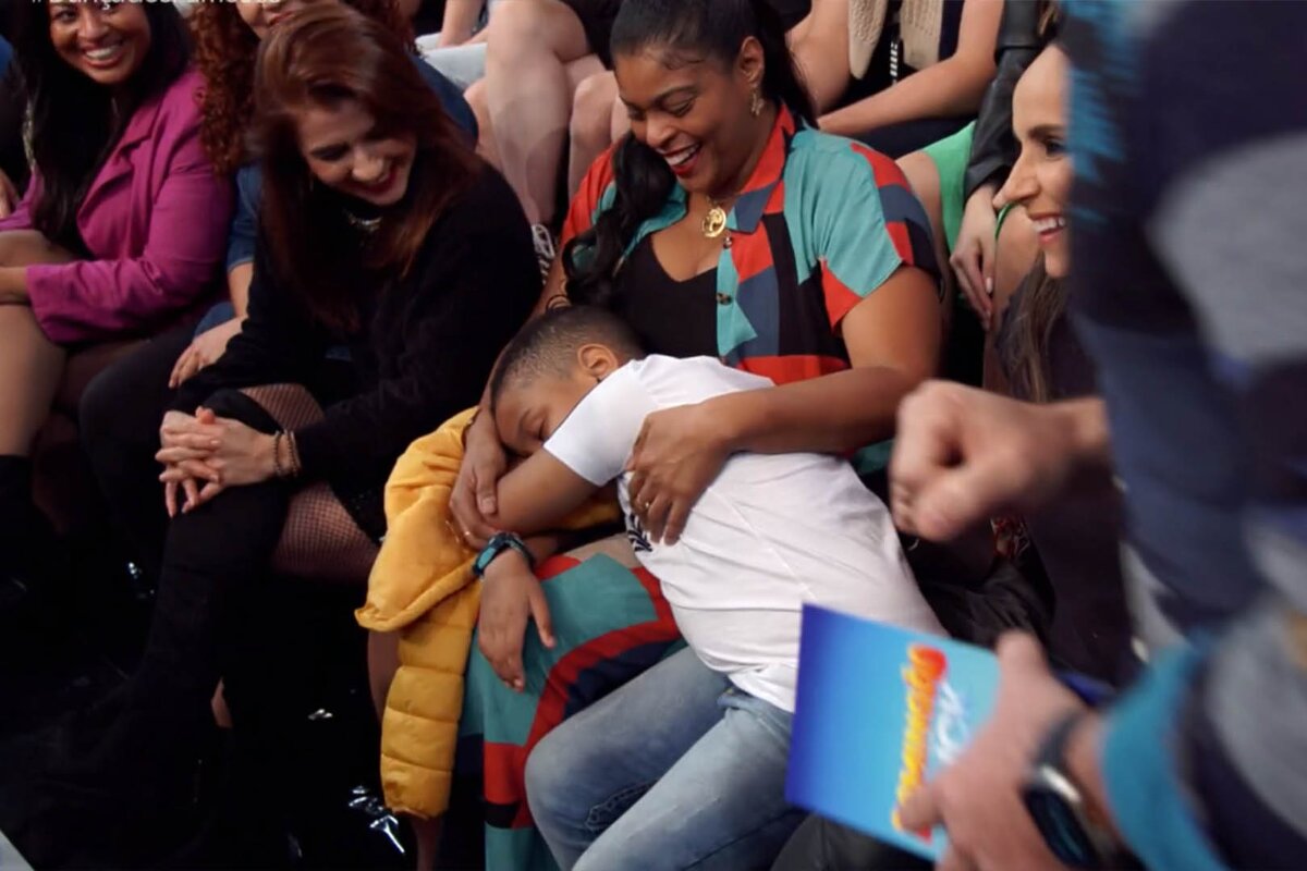 Menino dormindo no colo da mãe na plateia do "Domingão Com Huck"