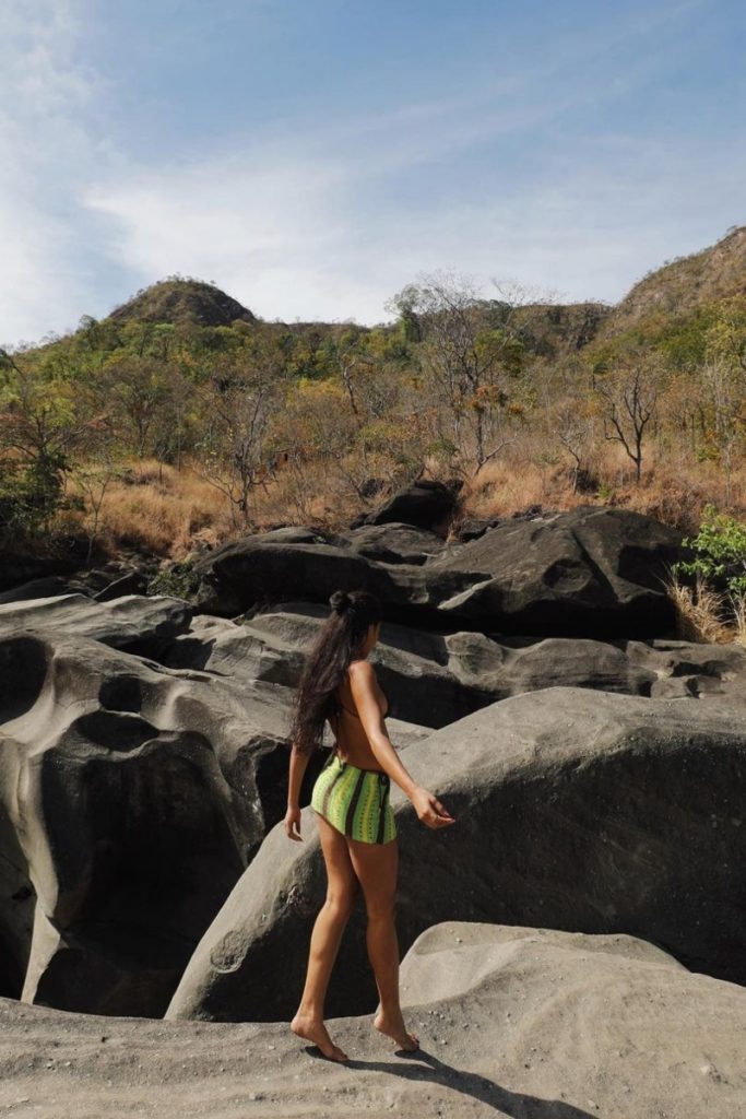 Bella Campos caminhando entre as pedras