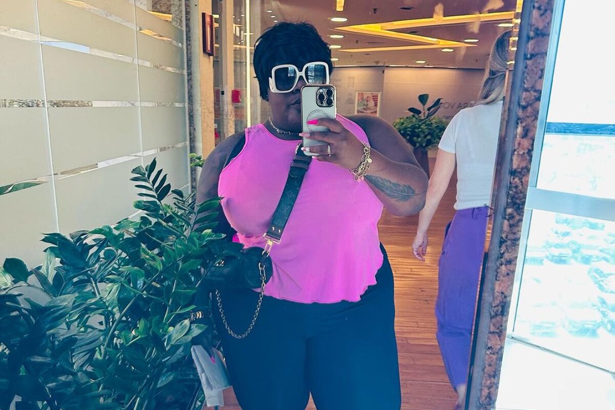 Jojo Todynho fazendo selfie declusa rosa e calça preta