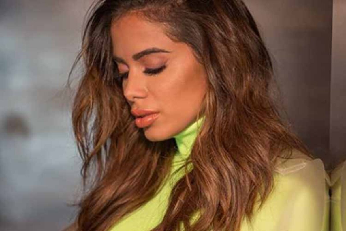 Anitta triste de camisa verde de gola alta