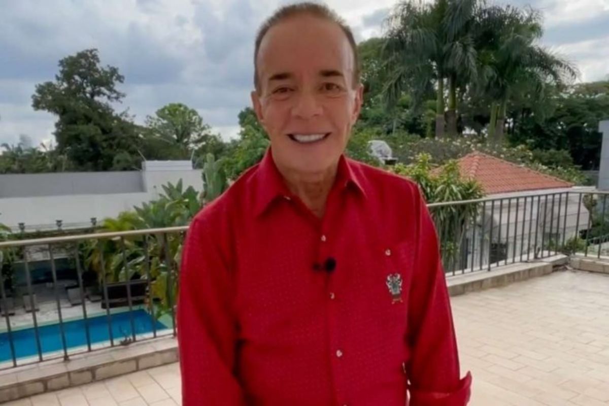 Chiquinho Scarpa, de camisa vermelha, com piscina ao fundo