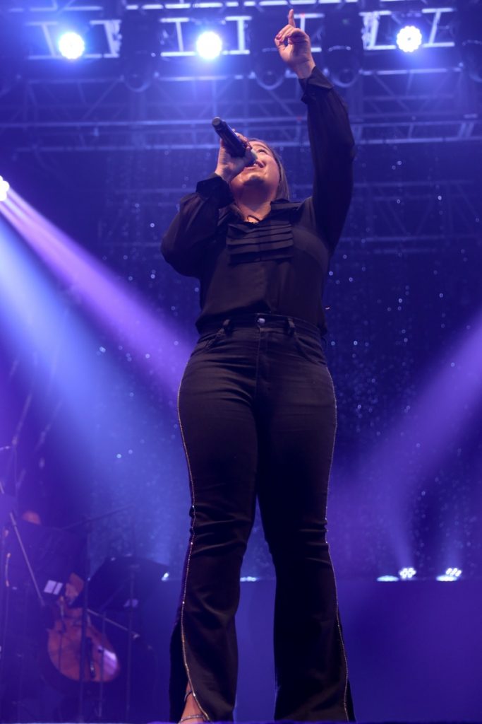 Jéssica Renata, de preto, cantando