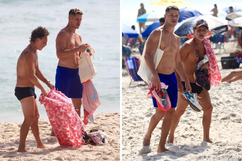 José Loreto de short azul na praia com amigo