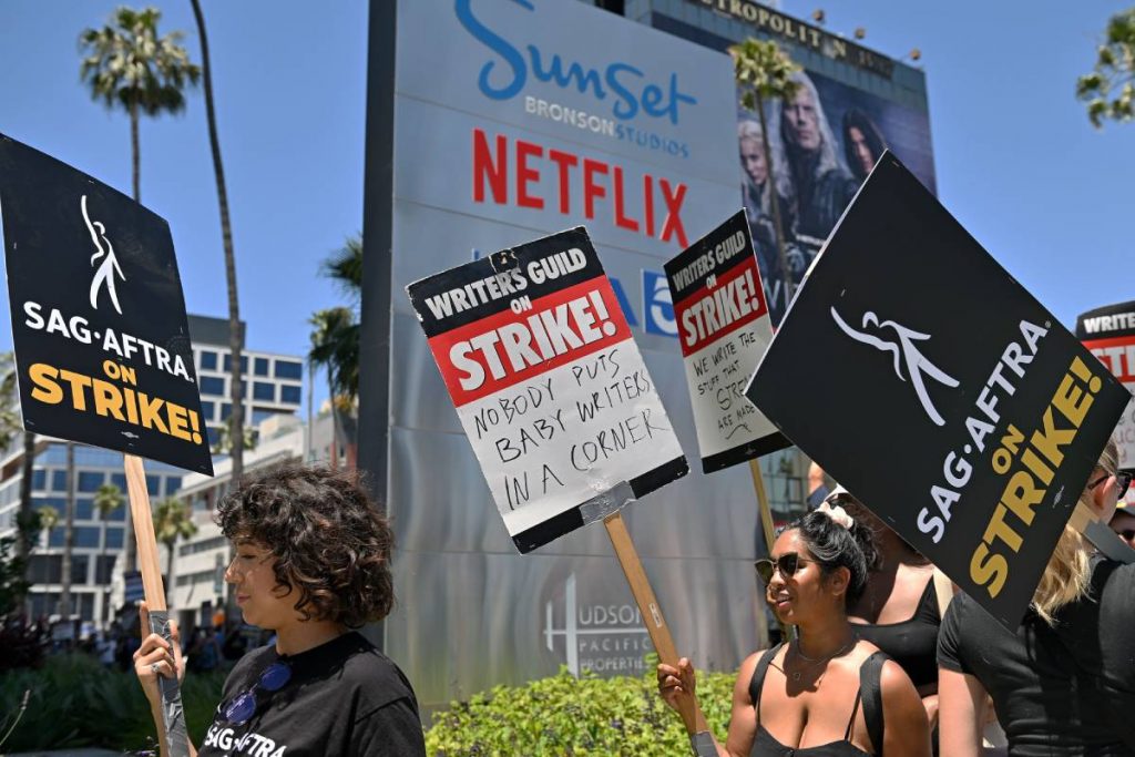 roteiristas e atores fazendo piquete de greve no escritório da netflix