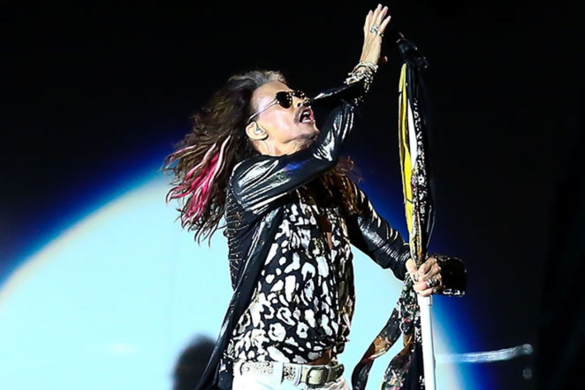 Steven Tyler cantando no palco com a banda Aerosmith
