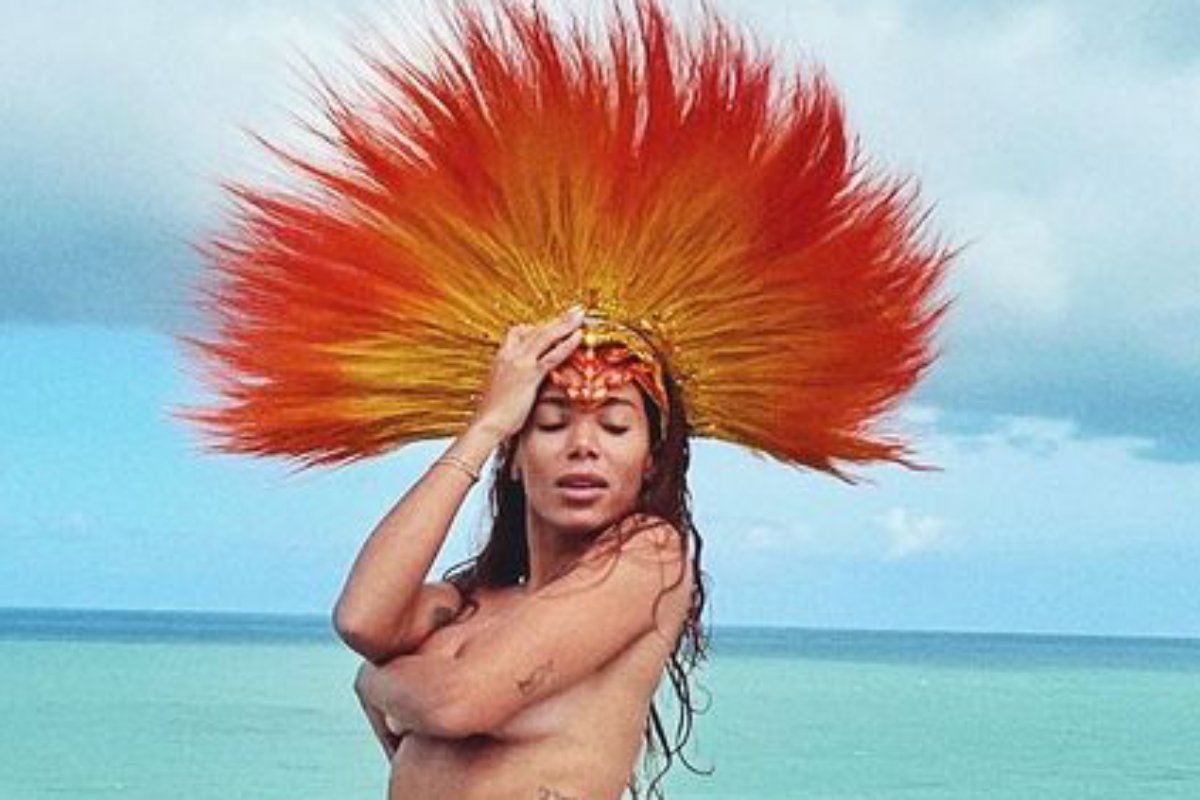 anitta posando nua com cocar de plumas