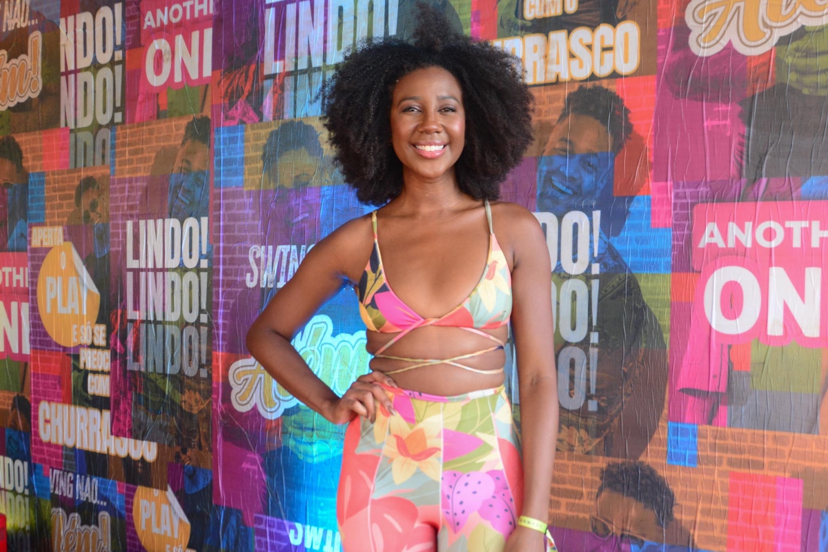 Camilla de Lucas de calça e top coloridos, cabelos naturais