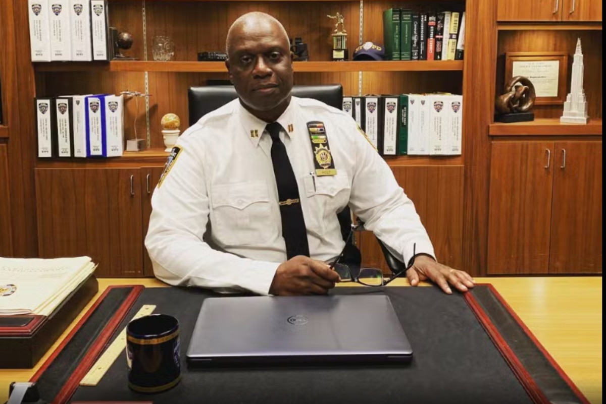 Andre Braugher vestido de policial, sentado, cena da série "Brooklin 99"