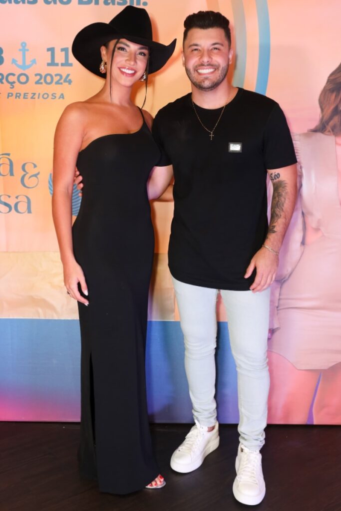 Gabriela Versiani de chapéu e vestido preto abraçada a Murilo Huff, de camisa preta e calça jeans clara