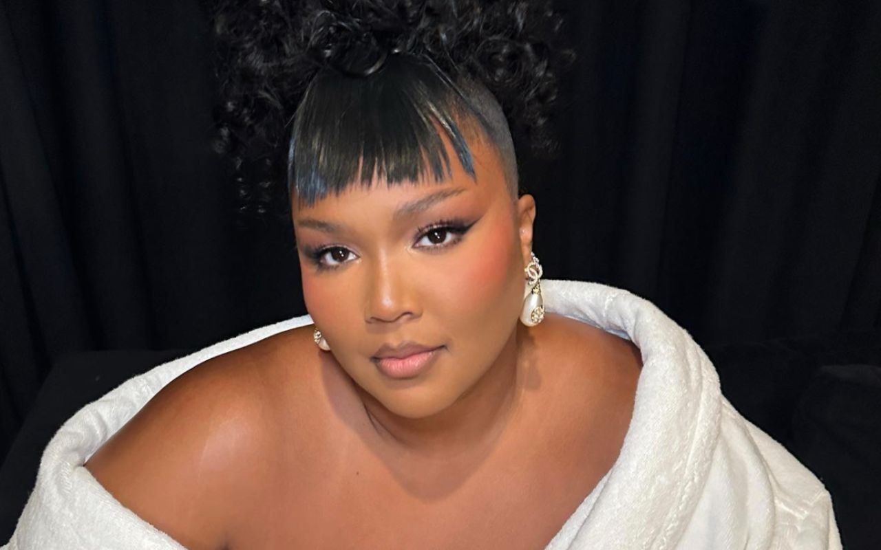 Lizzo sensual, de hobby branco e ombros a mostra