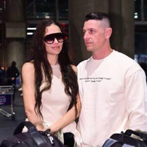 Em clima de romance, Adriana Lima desembarca no Brasil ao lado do marido e troca beijos apaixonados