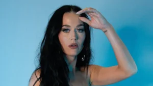 Katy Perry tenta arremessar bolo de aniversário em sua equipe