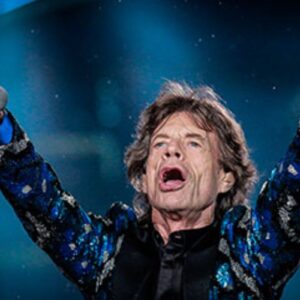 Mick Jagger no palco, com os braços para o alto