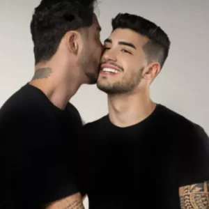Rico Melquiades beijando a bochecha de Matheus Freire