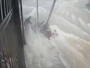 Motociclista escorrega e é levado por enxurrada enquanto pessoas tentam resgatá-lo; VEJA VÍDEO