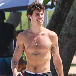Sem camisa e de calça, Shawn Mendes caminha na praia de São Conrado, no Rio de Janeiro